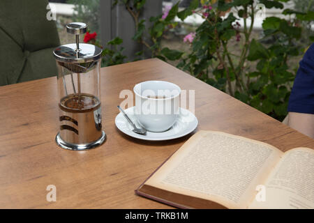 Winter tee Konzept. Frau Hände. Mädchen gießt Zitrusfrüchte Tee mit Zitronen und Orangen aus transparentem Glas Teekanne in eine Tasse. Stockfoto