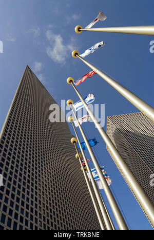 Fahnen gegen Himmel und hohes Gebäude, Ansicht von unten Stockfoto