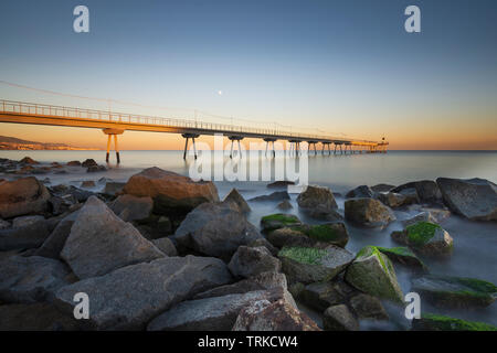 Brücke am Strand bei Sonnenaufgang Stockfoto