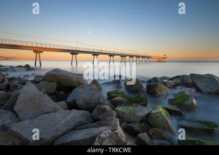 Brücke am Strand bei Sonnenaufgang Stockfoto