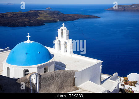 Eine Griechisch-orthodoxe Kirche mit Blick auf die Caldera von Santorin und die Ägäis in Fira, Santorini, Griechenland. Stockfoto
