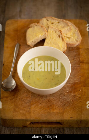 Frischen Lauch und Kartoffeln Suppe in einer Schüssel auf einem Holzbrett mit knusprigem Brot und Butter Stockfoto