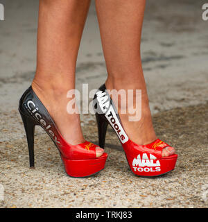 Meine Damen Beine in ein Paar rote und schwarze High Heel Schuhe Werbung Mac Tools und Ciceley Motorsport Stockfoto