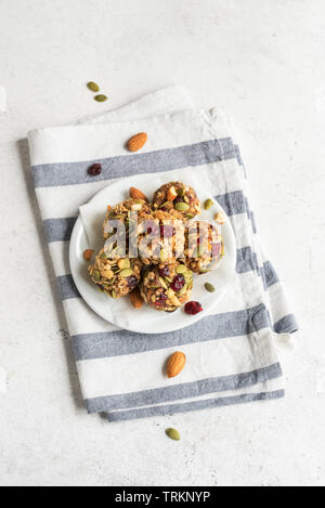 Energie Müsli mit Nüssen, Samen, chemische Preiselbeeren und Honig - vegan vegetarisch organischen snack Müsli Bissen auf weißem Hintergrund, kopieren. Stockfoto