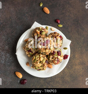 Energie beißt mit Nüssen, Samen, chemische Preiselbeeren und Honig - vegan vegetarisch organischen snack Müsli Bissen auf dunklem Hintergrund, kopieren. Stockfoto