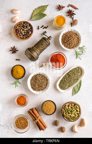 Verschiedene Gewürze auf weißem Hintergrund. Sortiment, set Gewürze und Würzen mit Vintage Pfeffermühle, Ansicht von oben, flach. Stockfoto