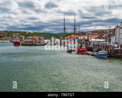 Whitby Harbour mit hohem Segelschiff, das neben modernen Fischerbooten festgemacht ist, sowie ein Touristenziel, das auch ein funktionstüchtiger Fischereihafen ist Stockfoto