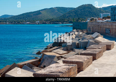 Große konkrete Würfel dienen die Wellen zu brechen und den Hafen auf der anderen Seite schützen. Cala Ratjada, Mallorca, Spanien. Stockfoto