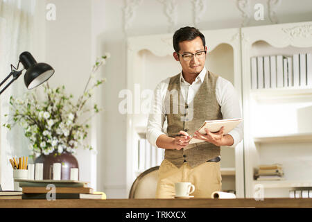 Jungen asiatischen Architekten Designer aus der Schreibtisch zu Hause arbeiten stehen Stockfoto