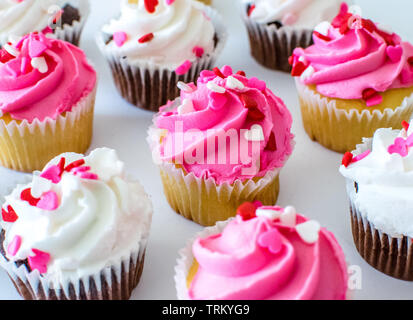 Valentine Cupcakes mit rosa und weißen Farbe zuckerguss und Herzen nach oben Streusel Stockfoto