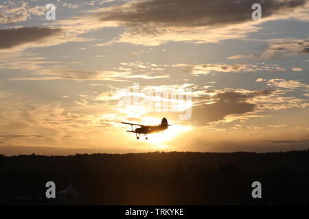 Antonov 2 oben am Himmel ein Sonnenuntergang fliegen. Stockfoto