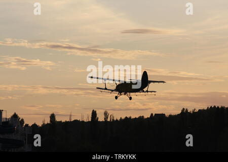 Antonov 2 oben am Himmel ein Sonnenuntergang fliegen. Stockfoto