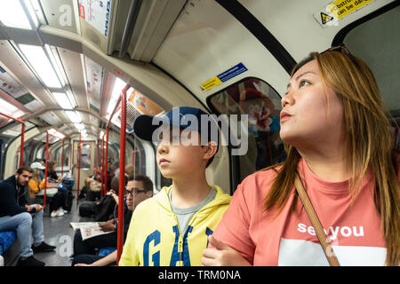 Eine Mutter und Sohn fahren mit dem Londoner U-Bahn auf einen Tagesausflug nach London. Stockfoto