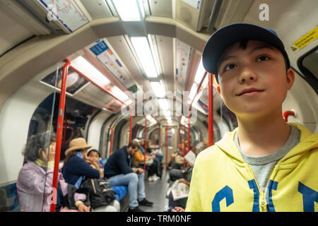 Ein kleiner Junge fährt auf einer Londoner U-Bahn während ona Tagesausflug nach London. Stockfoto