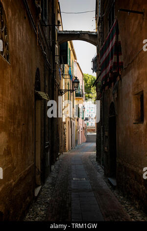 Malerische schmale Gasse mit einem Tuch, hängend trocknen, in Alassio, Ligurien, Italien. Stockfoto