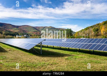Reihen von Solarzellen in einem Feld in den Bergen an einem sonnigen Herbsttag Stockfoto