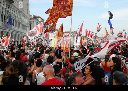 Venedig vom 8. Juni 2019. Nach dem Vorfall in der Lagune am 2. Juni, heute rund 20.000 Menschen gegen die großen Schiffe in Venedig gezeigt. Die friedliche Demonstration erreicht Piazza San Marco, wo es ein Treffen und ein fröhliches Volleyball übereinstimmen, die auch von der Polizei besucht wurde. Stockfoto