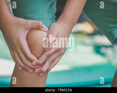 Kind Junge fühlen Knieschmerzen nach Spielen. gesund problem Konzept. Stockfoto