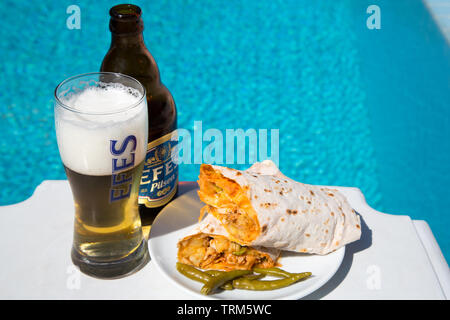 Eine Platte der Türkischen chicken Kebab (Tavuk Hartweizen} mit eine kalte Flasche Efes Pilsen Bier an einem sonnigen Nachmittag serviert am Pool, Marmaris, Türkei Stockfoto