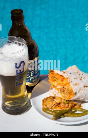 Eine Platte der Türkischen chicken Kebab (Tavuk Hartweizen} mit eine kalte Flasche Efes Pilsen Bier an einem sonnigen Nachmittag serviert am Pool, Marmaris, Türkei Stockfoto