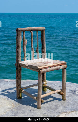 Holzstuhl in leeren Cafe neben Meer Wasser in tropischen Strand. Close Up. Insel Koh Phangan, Thailand Stockfoto