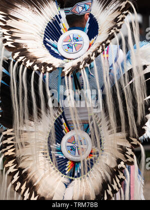 Nahaufnahme eines gefiederten Kopfschmuck und Hektik mit Perlen Medaillons von einem männlichen fancy Dancer bei einer nativen amerikanischen Pow Wow abgenutzt Stockfoto