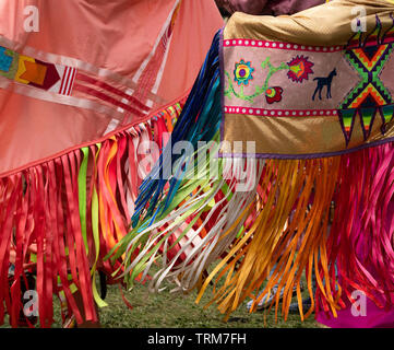 Zwei gebürtige amerikanische Frauen mit applizierten Schals mit bunten Band fringe Tanz an einem Pow Wow. Stockfoto