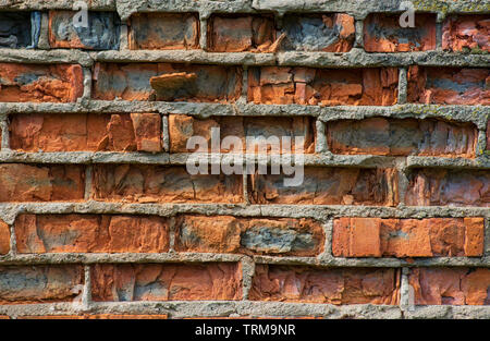 Risse vintage orange Backsteine, die in der Wand mit Zement Mauerwerk close-up Stockfoto