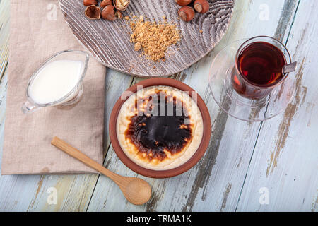 Türkische Küche dessert Sorten. Gebackener Reispudding türkisch Milch Nachtisch sutlac in irdenen Kasserolle mit Haselnüssen. Stockfoto