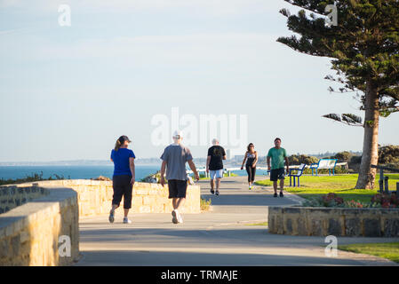 Am frühen Morgen Spaziergänger am Strand weg von Cottesloe und Scarborough Beach im Hintergrund. Stockfoto