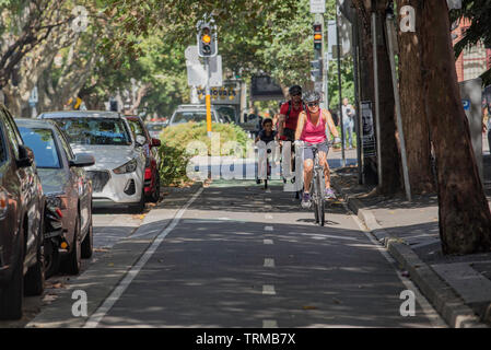 Ein Mann, eine Frau und ein kleines Kind reiten in einem dedizierten Fahrrad Lane im Sydney Vorort von Surry Hills in Australien Stockfoto