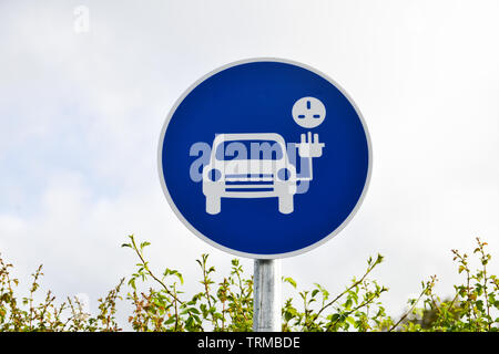 Ein Zeichen für ein Elektrofahrzeug aufladen Bucht und Parkplatz zeigt ein Bild von einem elektrisch angetriebene Auto und führen. Stockfoto