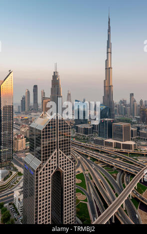 Der Burj Khalifa und der Innenstadt von Dubai einschließlich einer massiven Autobahn Interchange bei Sonnenuntergang Stockfoto