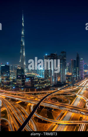 Der Burj Khalifa und der Innenstadt von Dubai einschließlich einer massiven Autobahn Interchange bei Sonnenuntergang Stockfoto