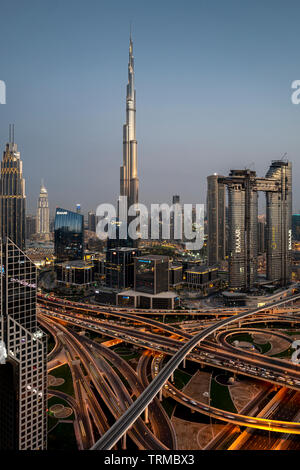 Der Burj Khalifa und der Innenstadt von Dubai einschließlich einer massiven Autobahn Interchange bei Sonnenuntergang Stockfoto