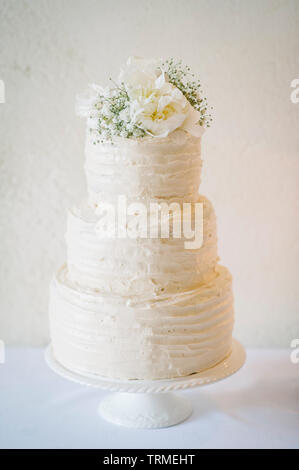 Elegante, traditionelle Tiered weisse Hochzeitstorte mit Blumen dekoriert Stockfoto