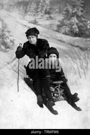 Frauen und Kinder auf vintage Holz Schlitten/Rodel - 1910/1920 Stockfoto