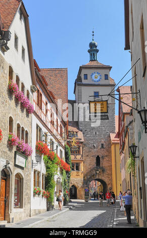 Rothenburg ob der Tauber, Deutschland - August 2015: Mittelalterliche Straße Szene mit Gate Tower und engen Bogen weg durch die Ummauerte Festung zusammen mit ein paar touristische enjoyi Stockfoto