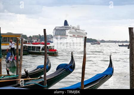 Ein grosses Kreuzfahrtschiff in Venedig als von der Waterfront mit Gondeln im Vordergrund, Italien Europa EU Stockfoto