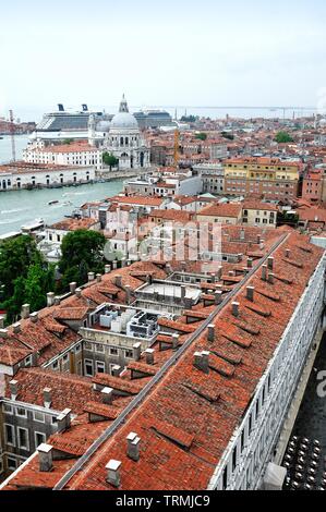 Die Dächer von Venedig durch eine große Kreuzfahrtschiffe in den Hafen entlang des Canale della Giudecca dominiert, Italien Europa Stockfoto