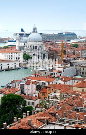 Die Dächer von Venedig durch eine große Kreuzfahrtschiffe in den Hafen entlang des Canale della Giudecca dominiert, Italien Europa Stockfoto