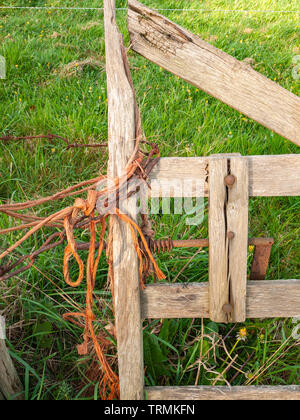 Detail des alten hölzernen Tor Medaillon mit orange Garn und Kette Stockfoto