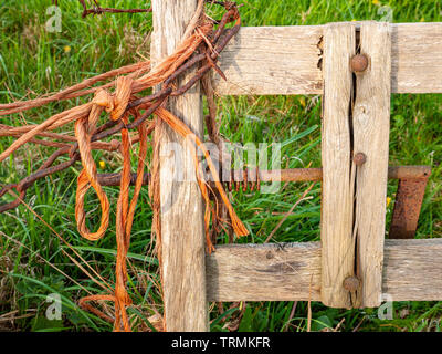 Detail des alten hölzernen Tor Medaillon mit orange Garn und Kette Stockfoto