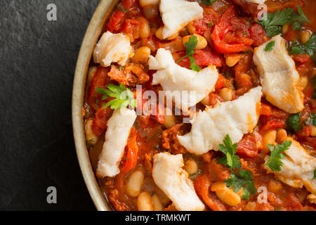 Ein Pollack und Chorizo Wurst fisch Eintopf mit Tomaten, geröstete Paprika, Tomaten aus der Dose, gehackte Zwiebeln, cannellini Bohnen und Petersilie. T Stockfoto