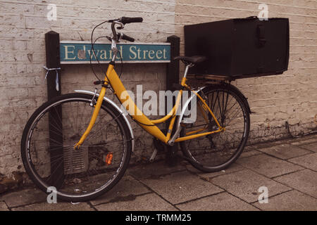 Alten retro Gelb bicecle Park neben dem Straßenschild. Stockfoto