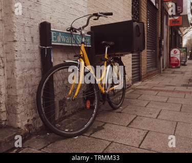 Alten retro Gelb bicecle Park neben dem Straßenschild. Stockfoto