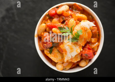 Ein Pollack und Chorizo Wurst fisch Eintopf mit Tomaten, geröstete Paprika, Tomaten aus der Dose, gehackte Zwiebeln, cannellini Bohnen und Petersilie. T Stockfoto