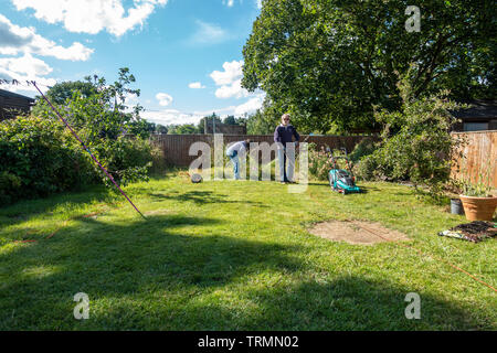 Ein rentnerehepaar Tun im Garten an einem sonnigen Tag mit blauen Himmel im Frühsommer. Stockfoto