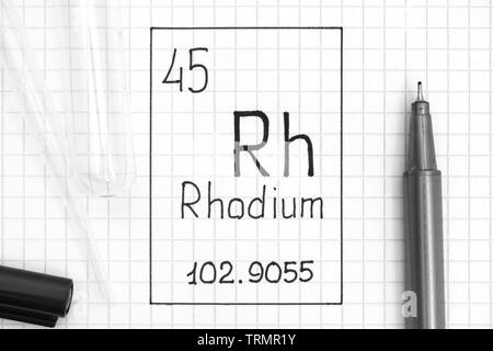 Das Periodensystem der Elemente. Handschrift chemische Element Rhodium Rh mit schwarzem Stift, Reagenzglas und Pipette. Close-up. Stockfoto