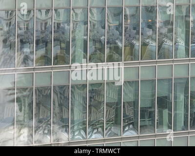 Nahaufnahme der Zeilen von Windows in einem modernen Büro Hochhaus im Zentrum von London; mehrere Reflexionen von anderen Gebäuden erstellen Wellen und Muster Stockfoto